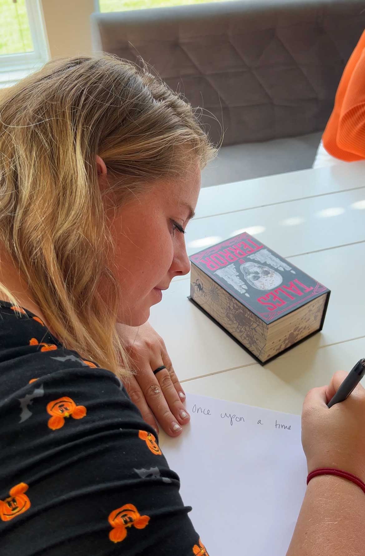 woman writing something on a piece of paper