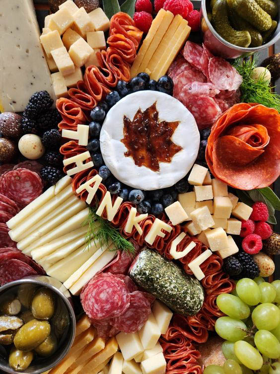 cheeseboard with meat, cheese, and fruits and THANKFUL letter made from cheese