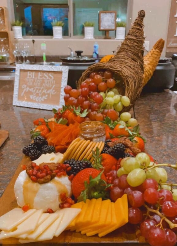 decorative cornucopia stuffed with fruits, cheese, and jams