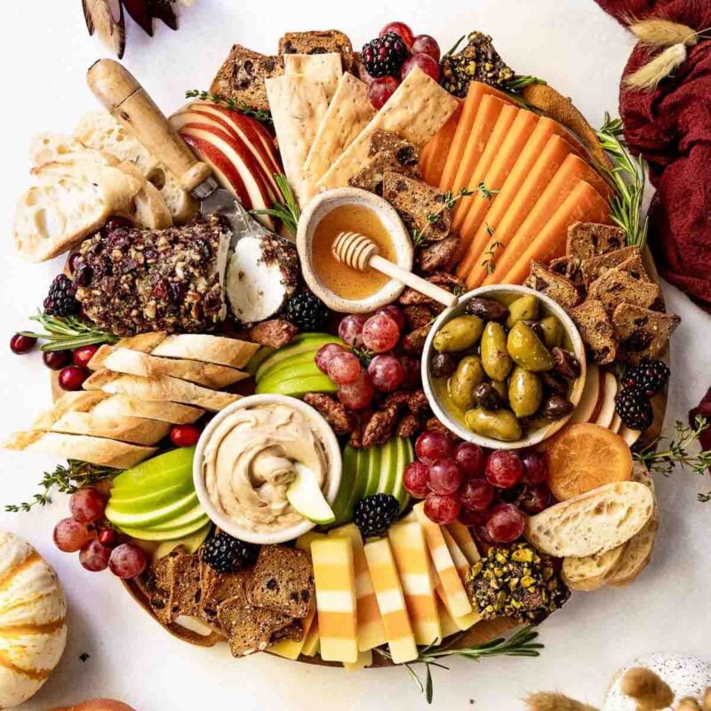 round board with fruits, crackers, and jams