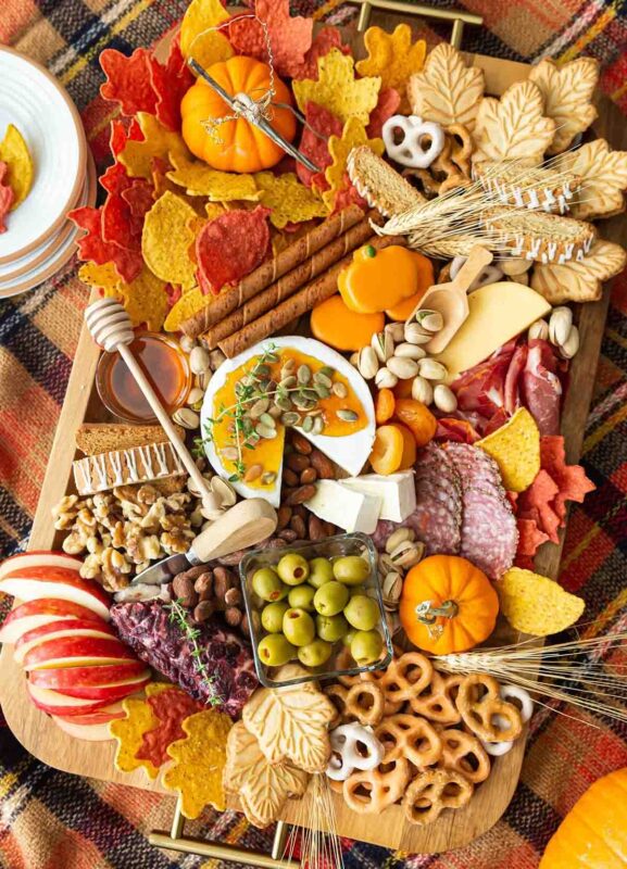 rectangular board with leaf crackers, cookies, and other fall colored snacking items
