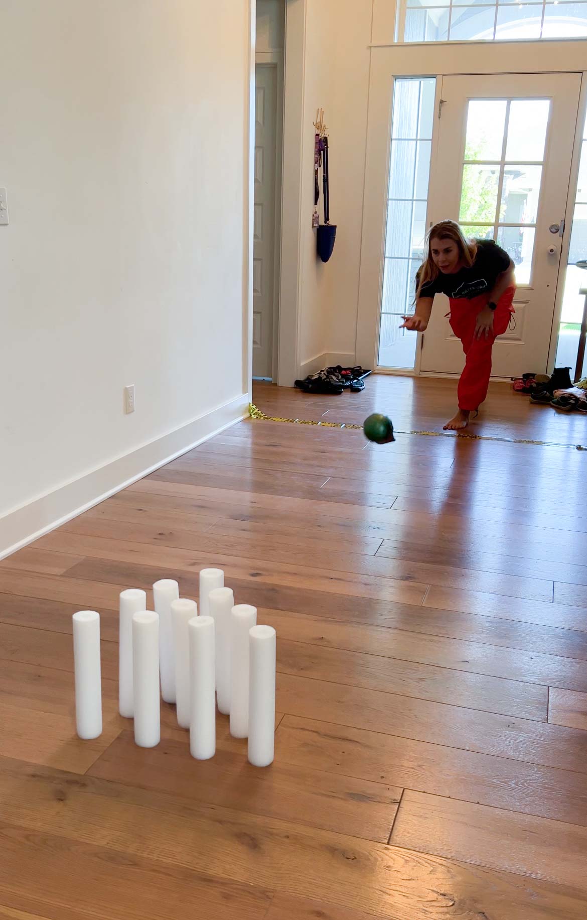 woman bowling a skull into ghost bowling pins