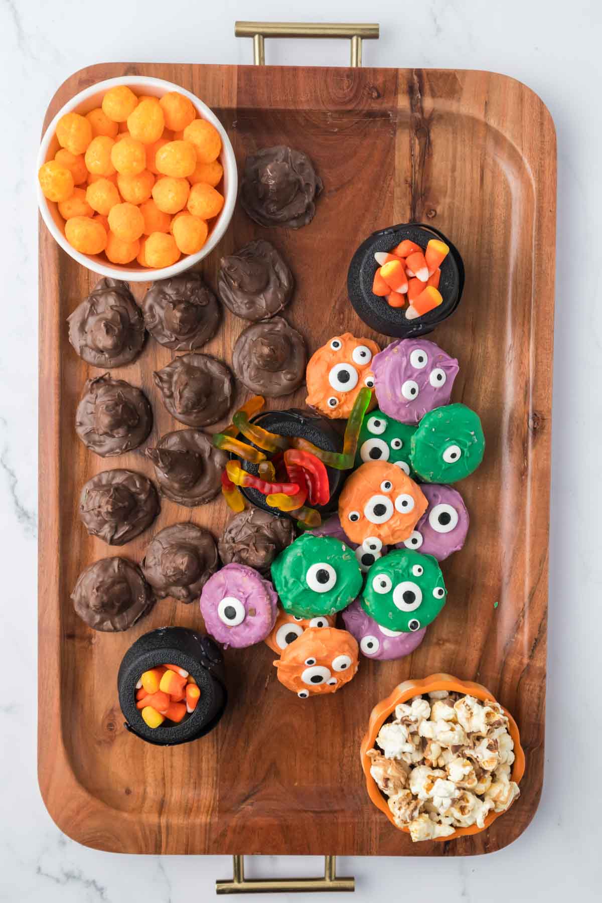 Halloween snack board with chocolate hats and monster cookies