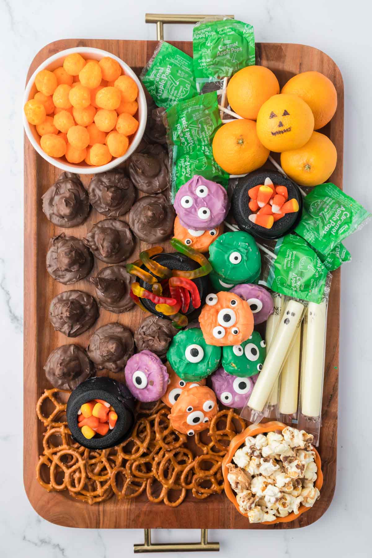 Halloween snack board with pumpkins, string cheese ghosts, and more