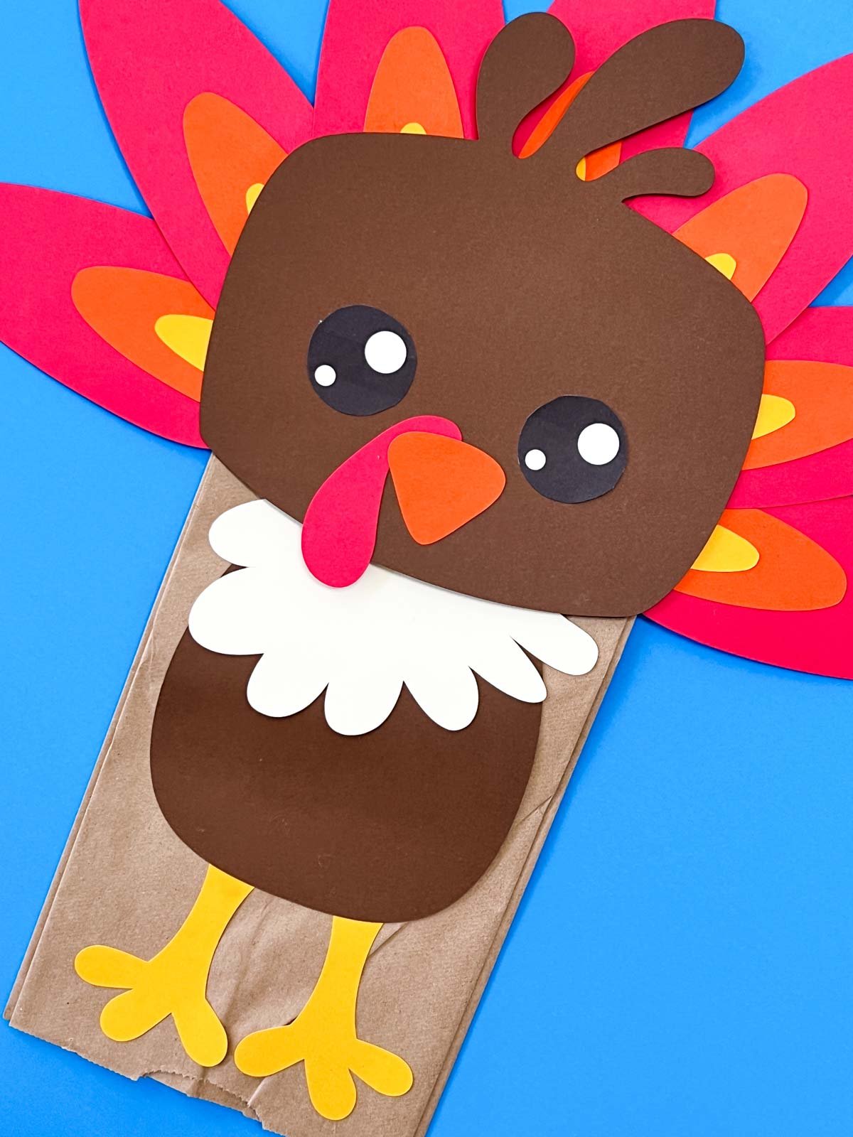 paper bag turkey craft on a blue background