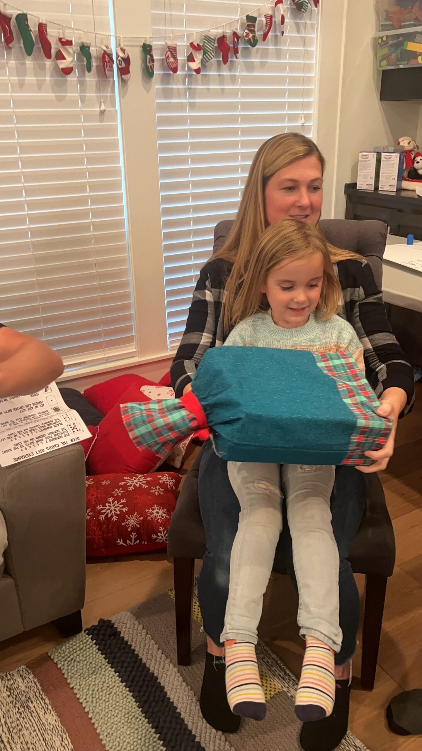 mom and daughter sitting with a gift in their lap