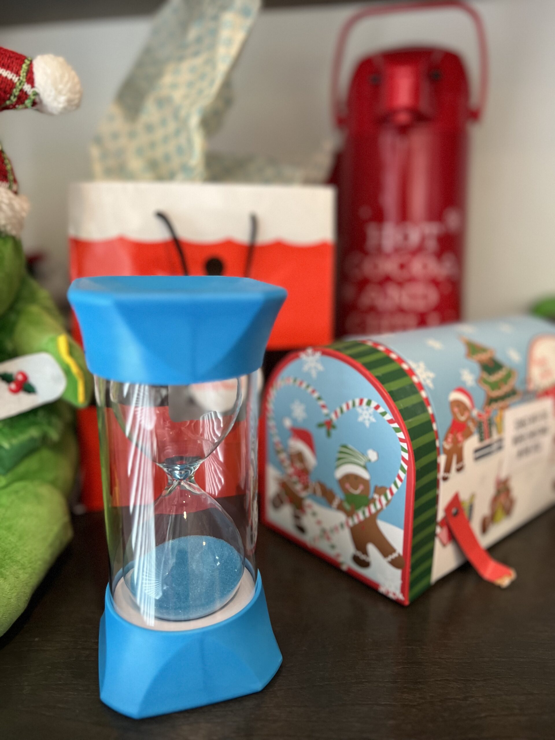 large hourglass with a pile of wrapped gifts