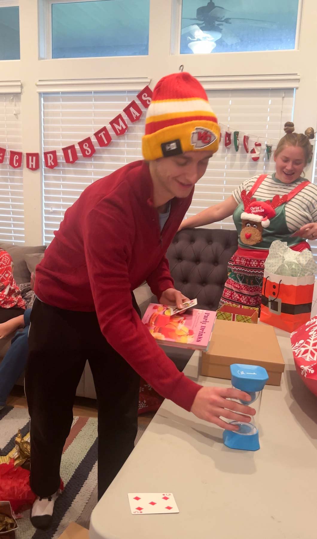 teen flipping an hourglass on a table full of gifts