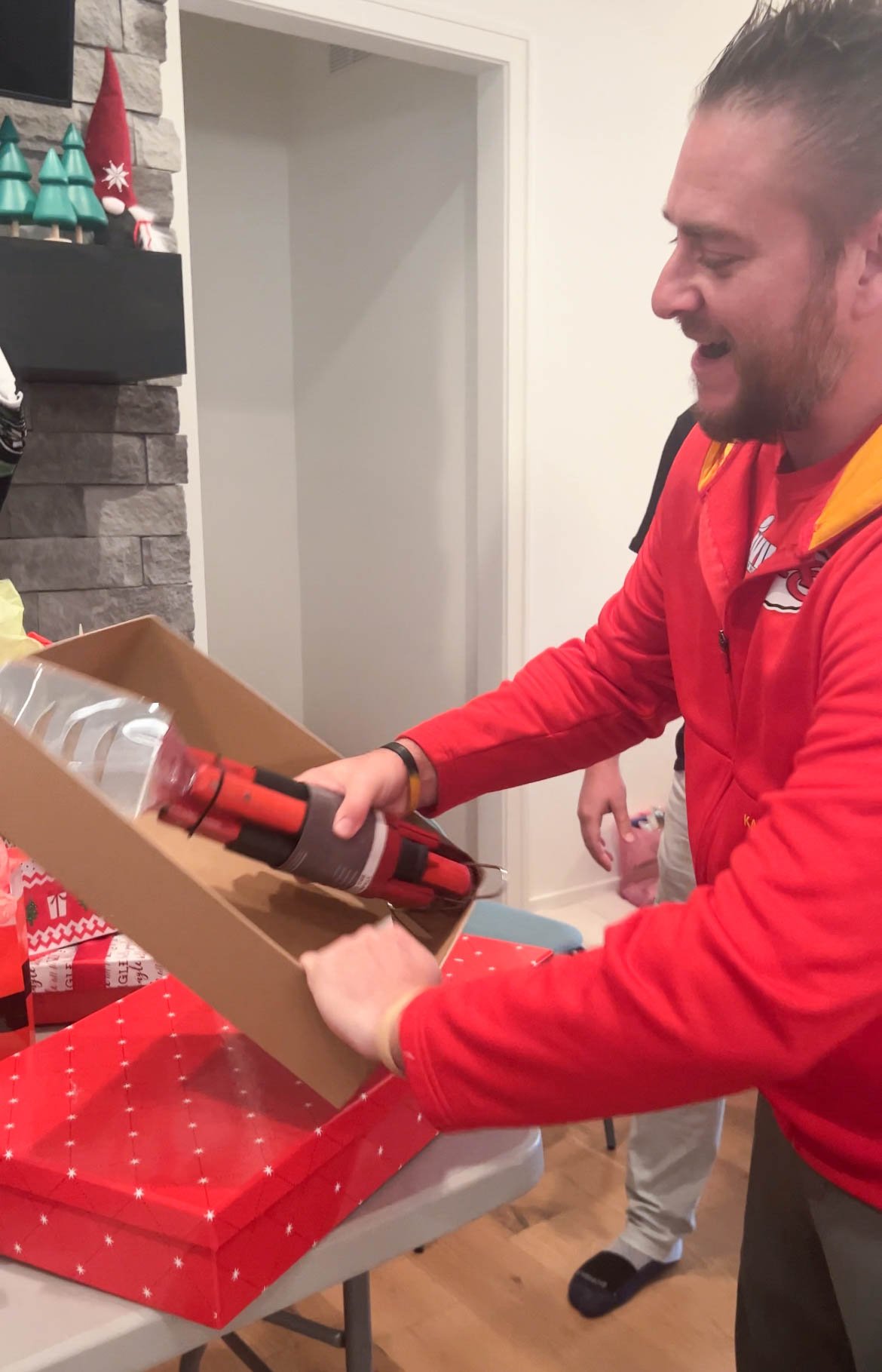 man opening a gift of grill tools