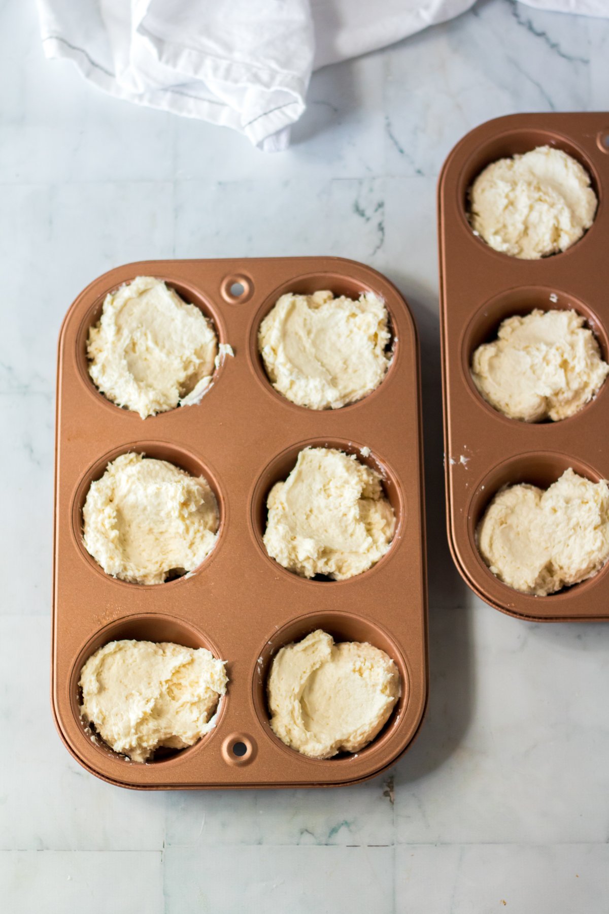biscuit batter in muffin tins, ready to rest and rise. 