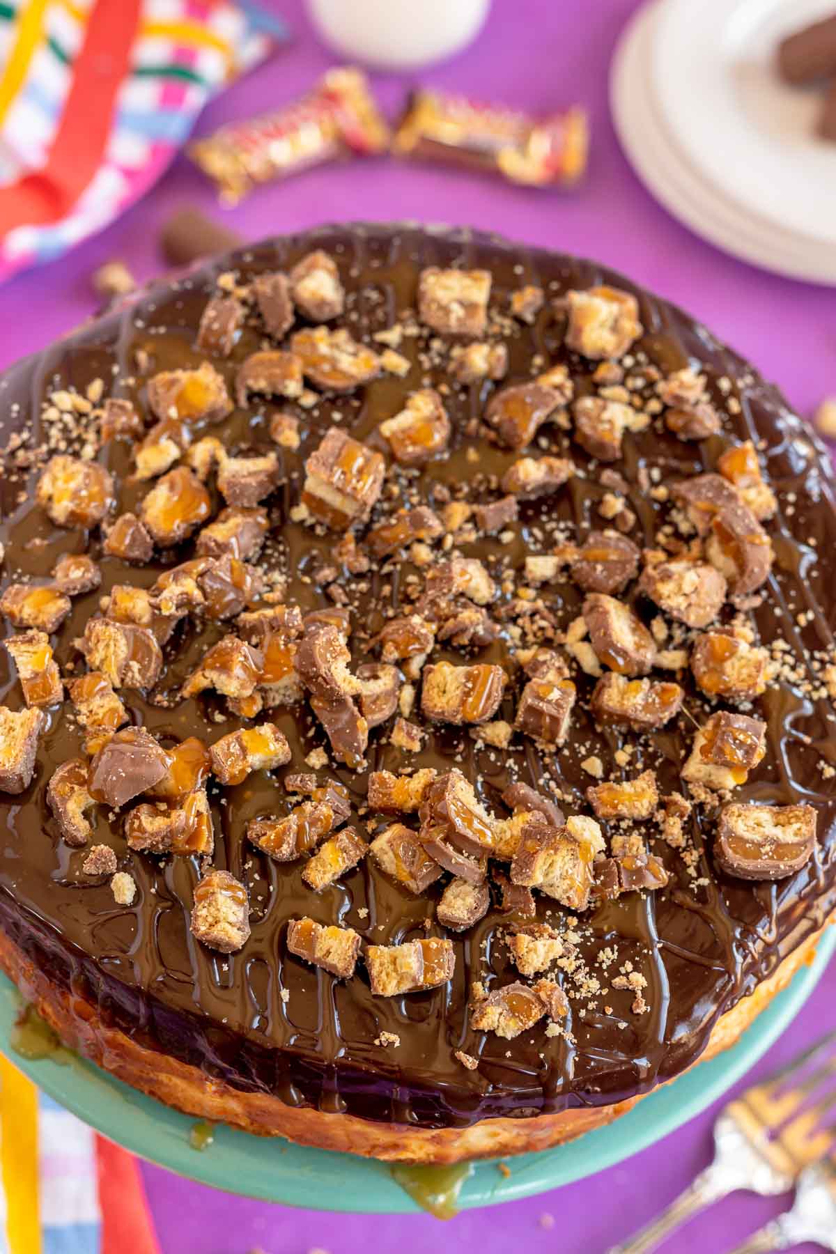 uncut twix cheesecake on a cake stand