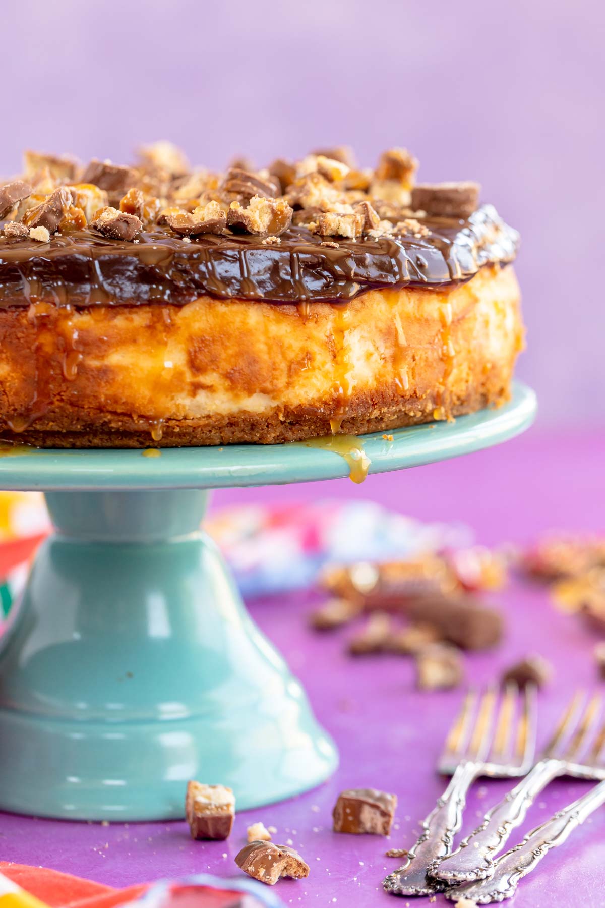 twix cheesecake on a blue cake stand