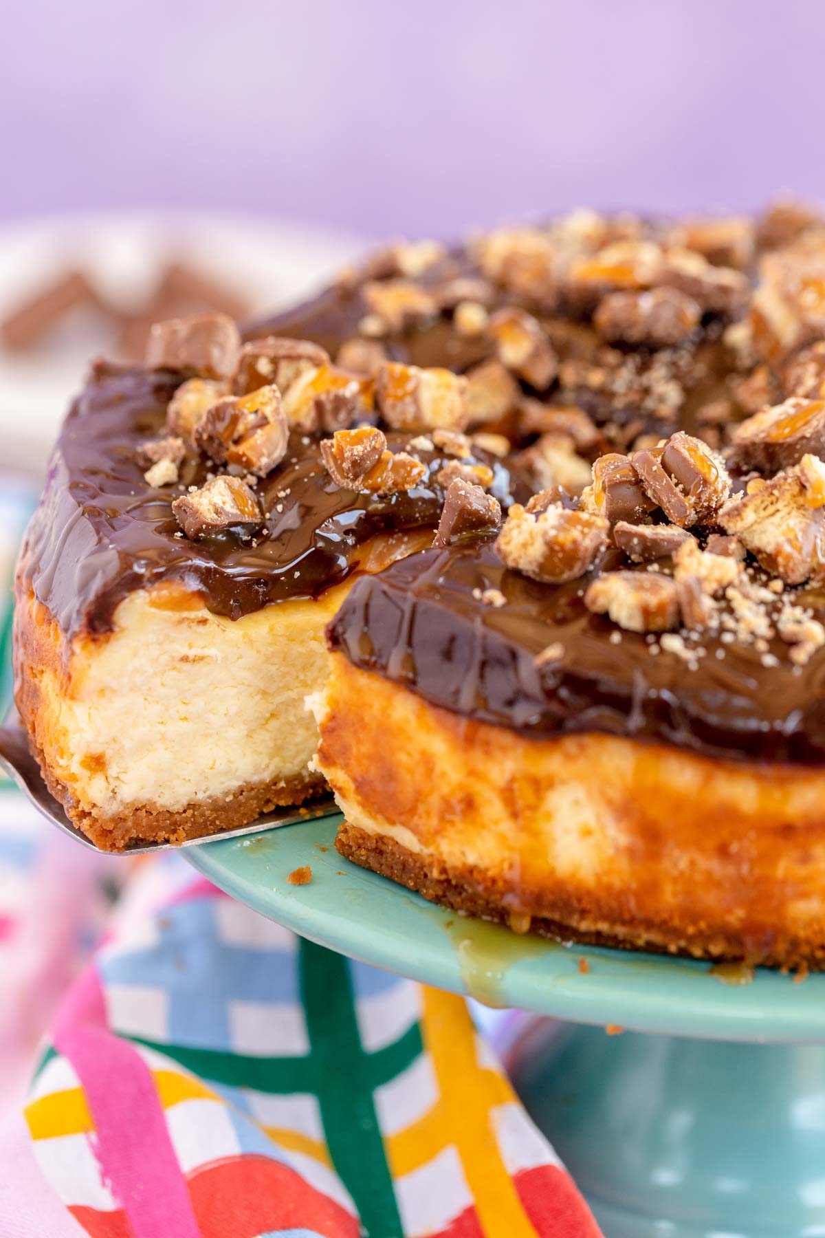 sliced twix cheesecake with a piece being pulled away