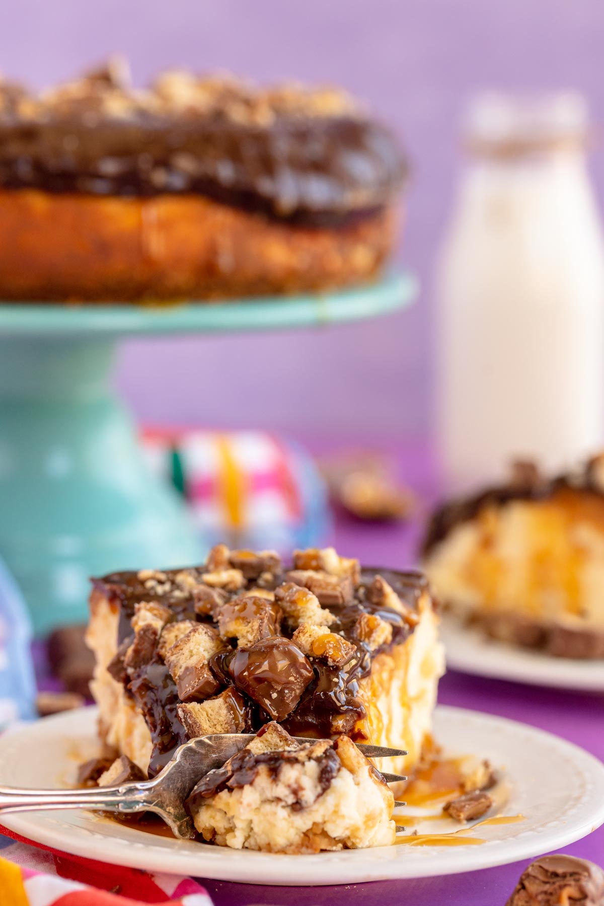 slice of twix cheesecake with a bite taken out of it
