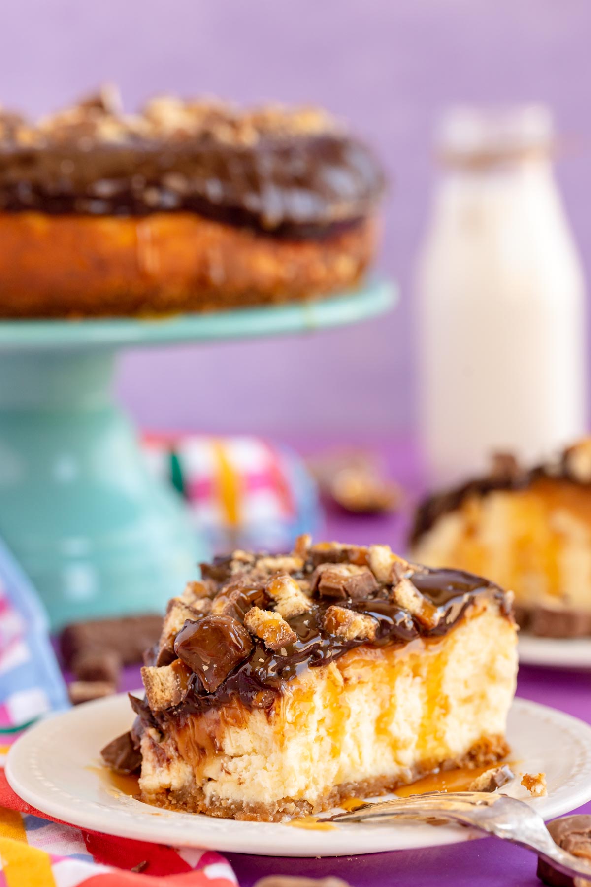 slice of Twix cheesecake on a pink plate