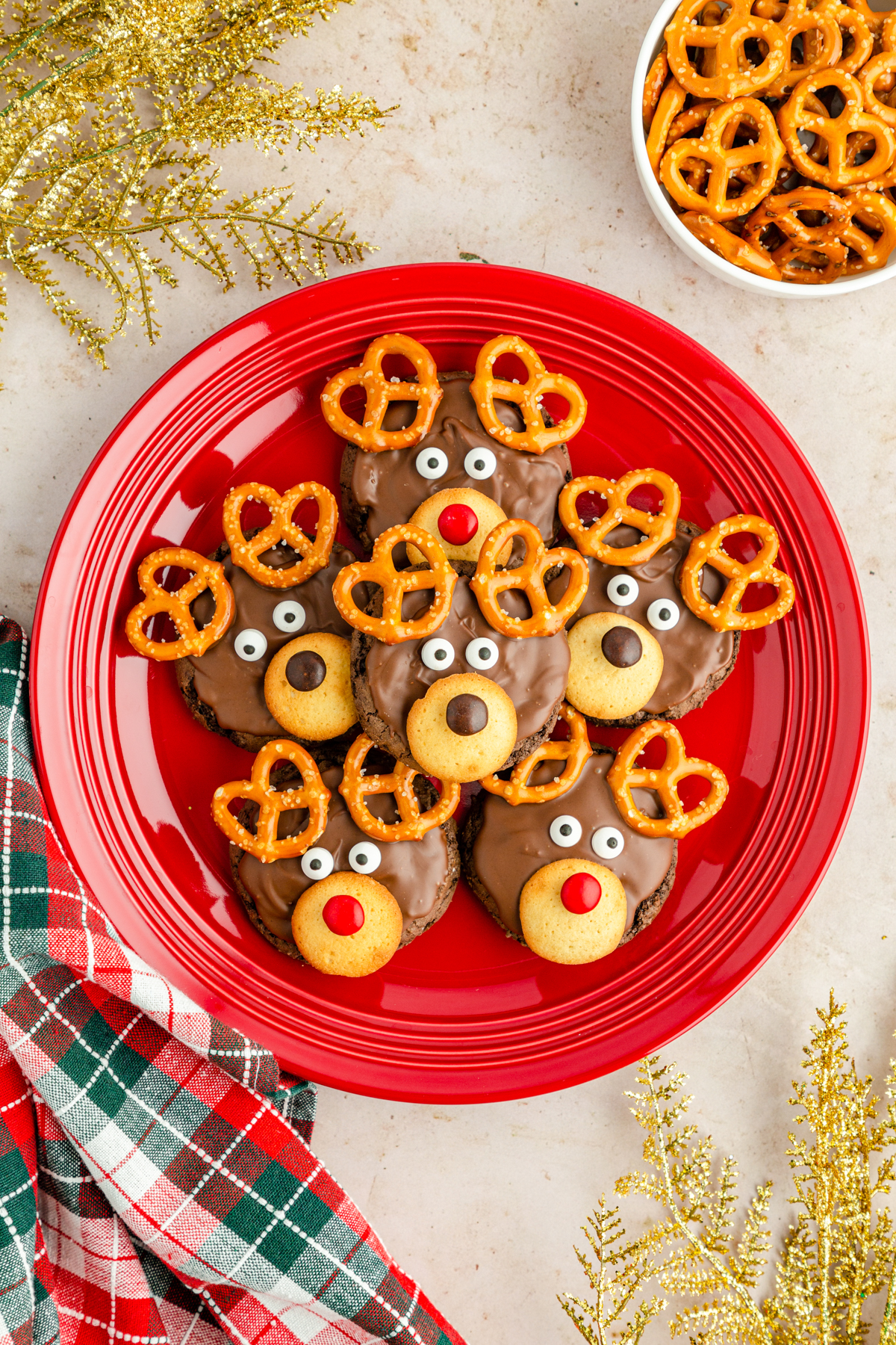 red plate full of reindeer cookies stacked on top of each other