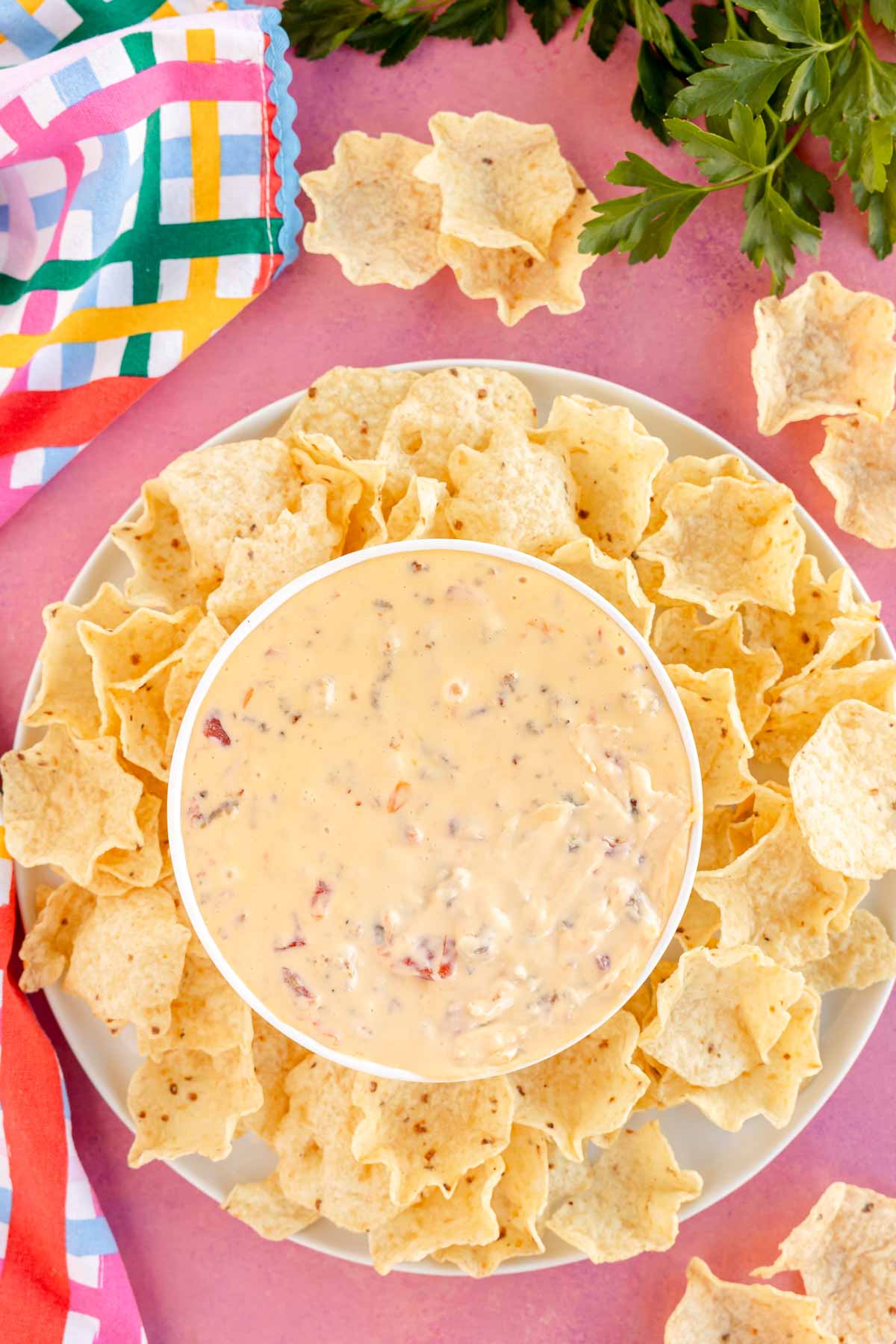 white bowl of velveeta sausage cheese dip surrounded by tortilla chips