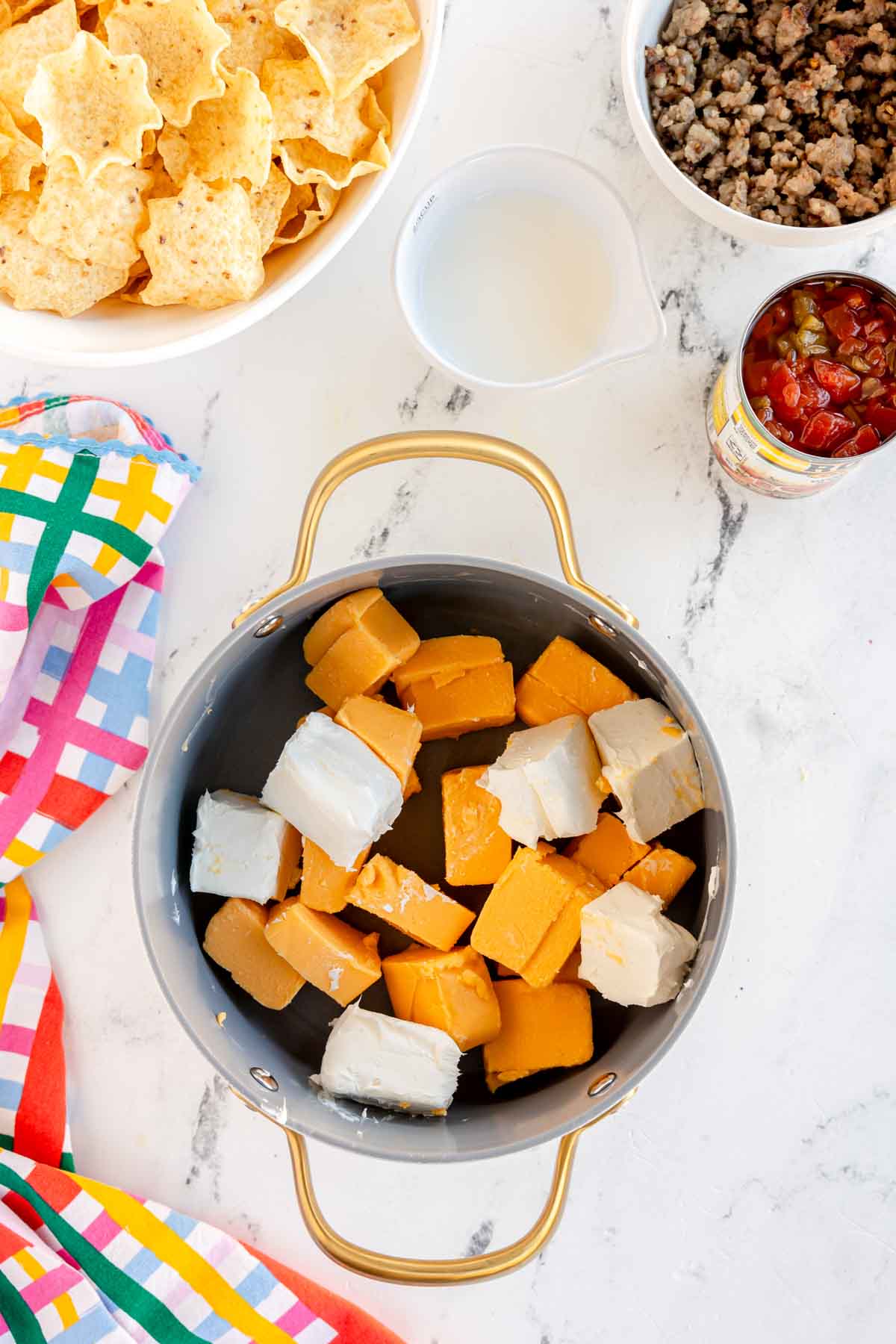 cream cheese and velveeta cubes in a pot