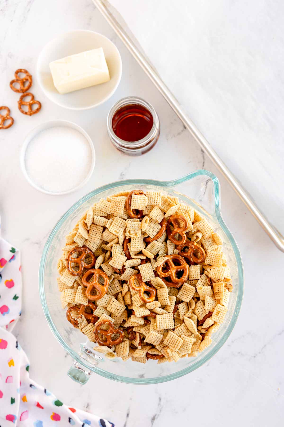 glass bowl with ingredients to make a sweet chex mix