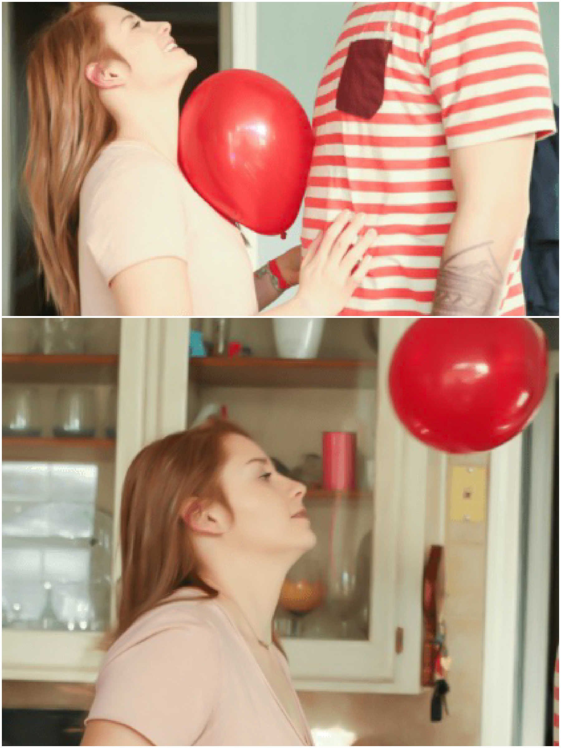 2 people trying to keep a balloon off the ground by bouncing it off each other. 