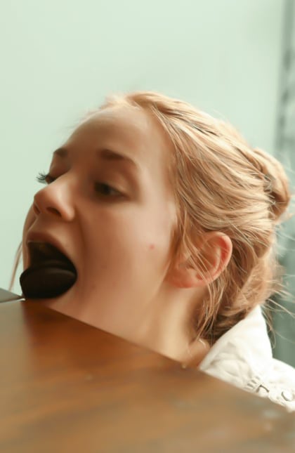 one women bending down to have a cookie fall into her mouth. 