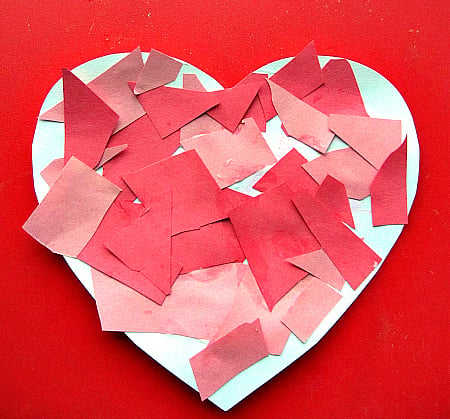 white paper heart with cut out red paper glued on