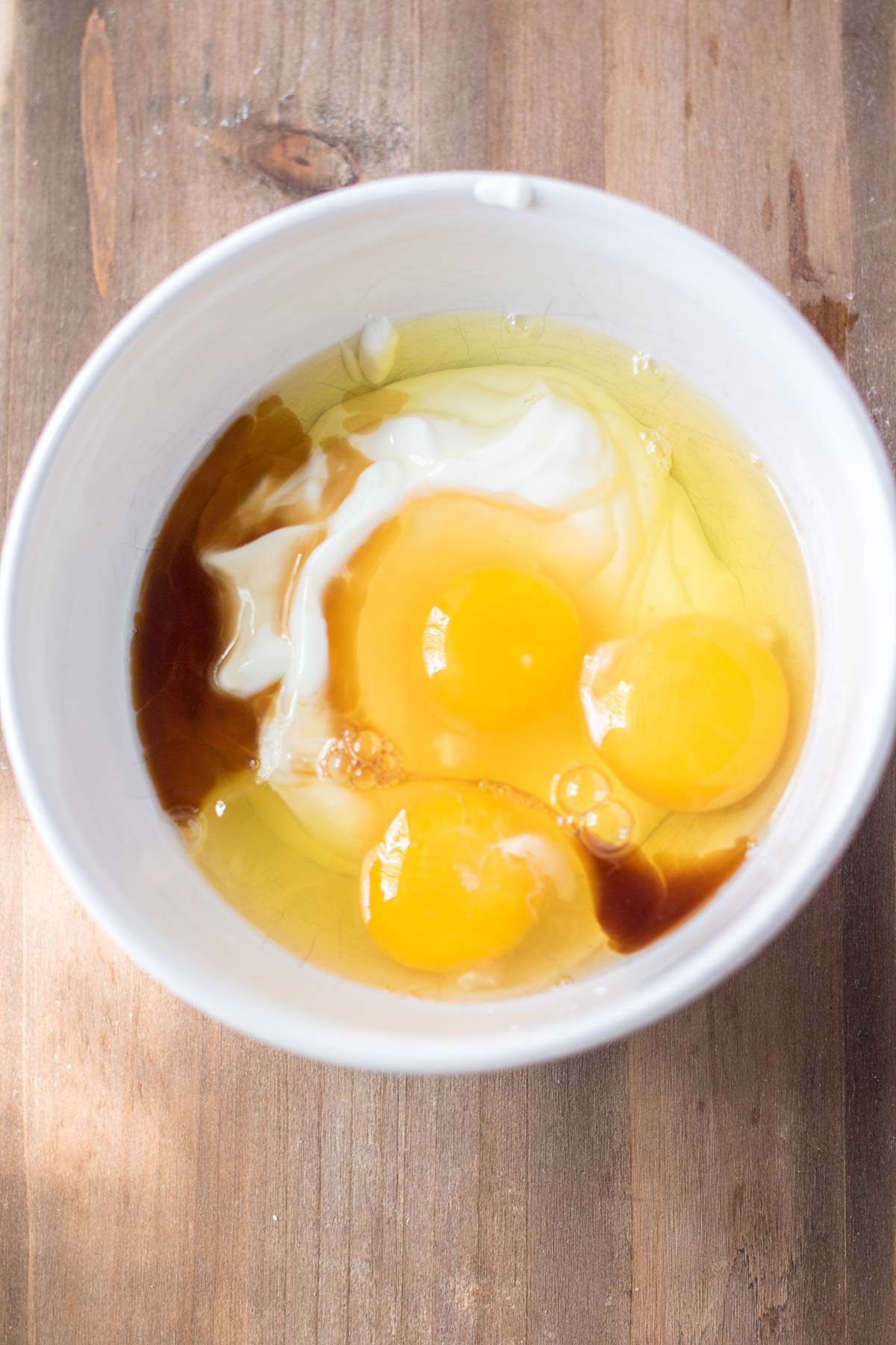 eggs and other wet ingredients in a while bowl