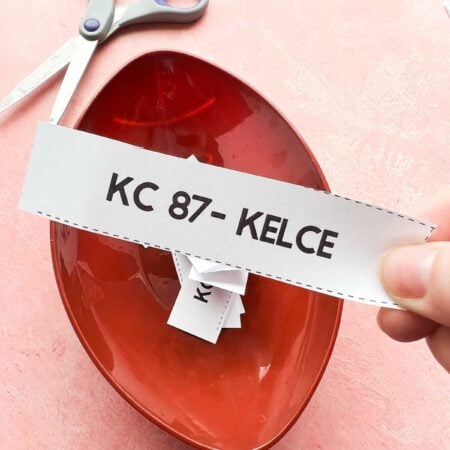 hand holding a piece of paper that says 87 - Kelce