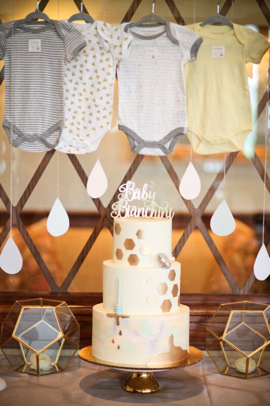 beehive decorated cake with onesies hanging above