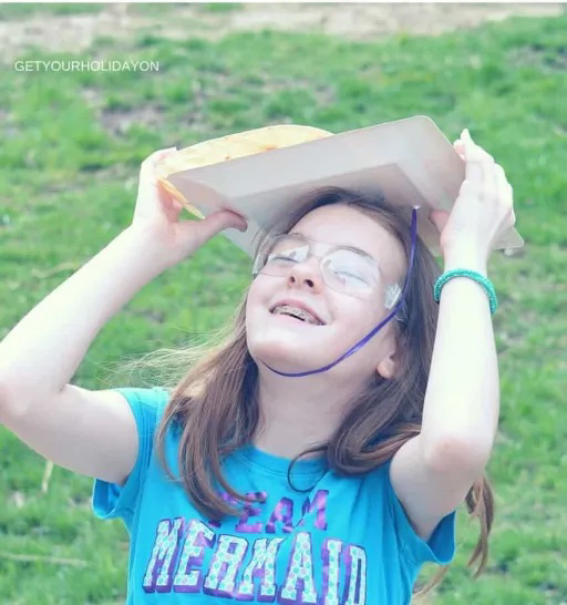 girl with a plate on her head trying to catch a tortilla