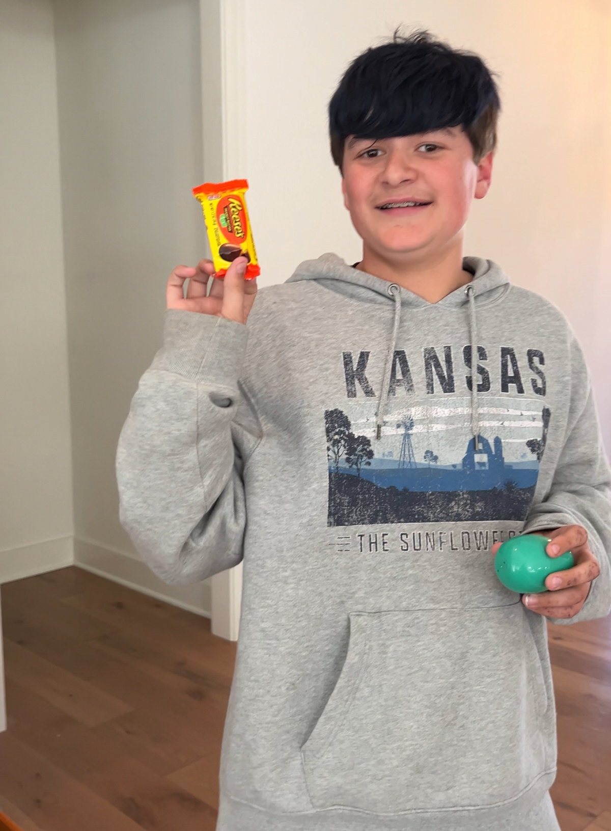 teen boy holding an egg and candy