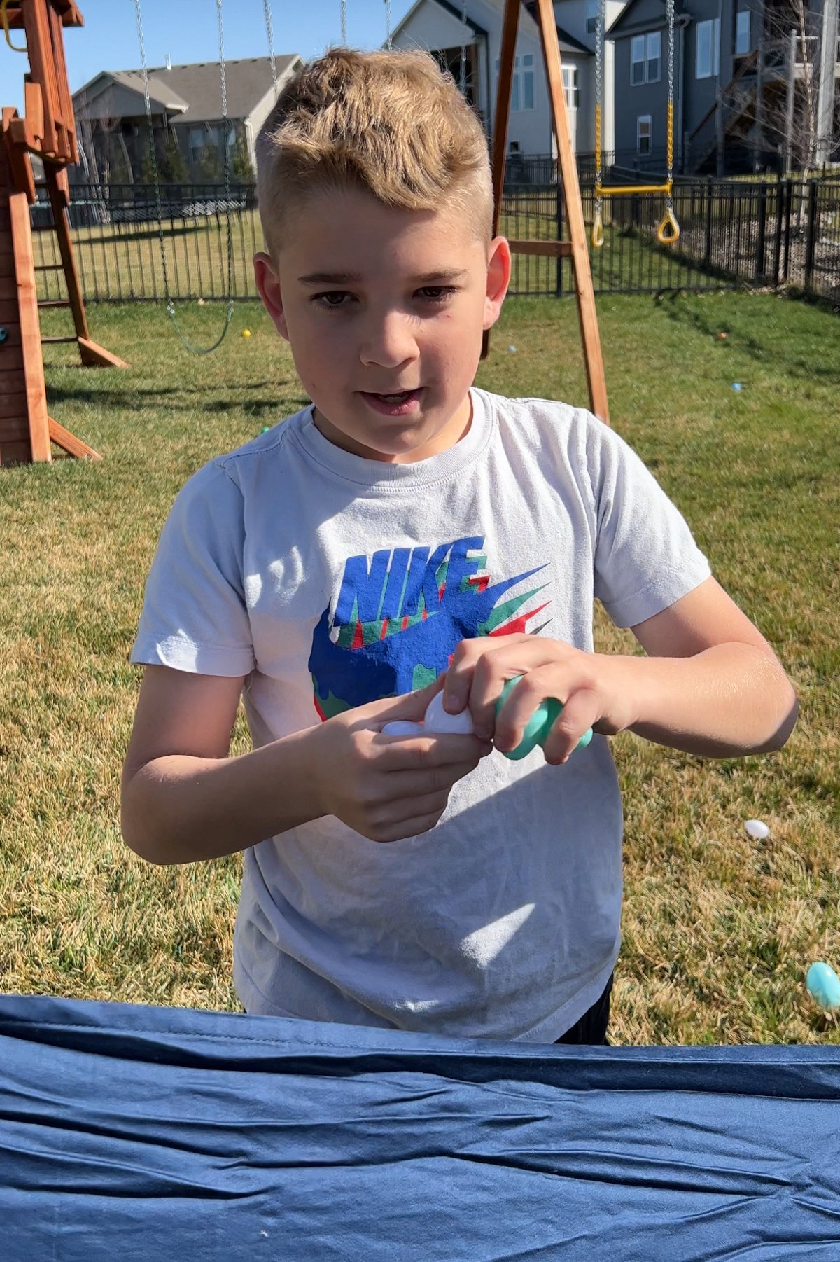 tween boy opening a plastic egg 