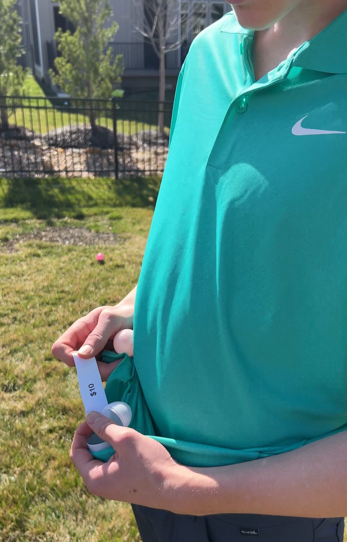 teen boy reading a piece of paper with $10 on it