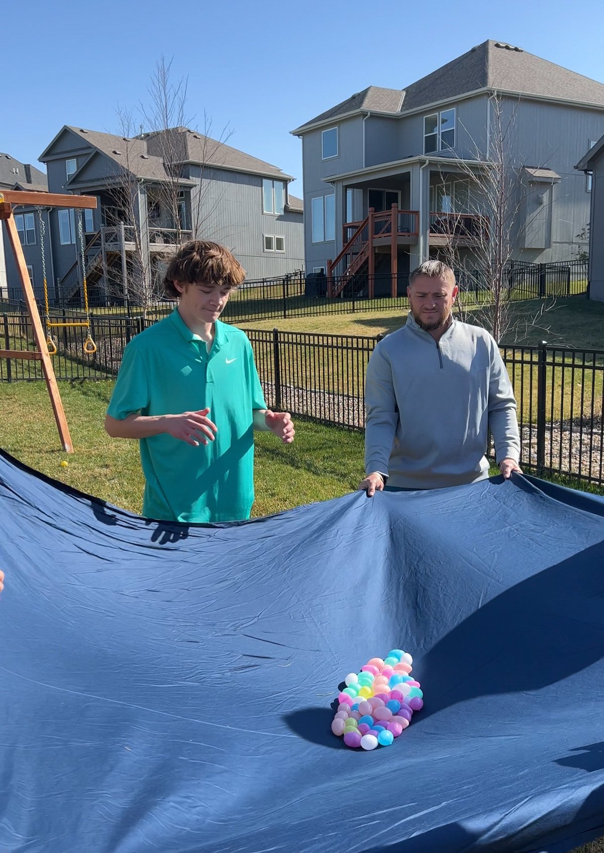 plastic eggs on a sheet with people standing around waiting for an egg toss