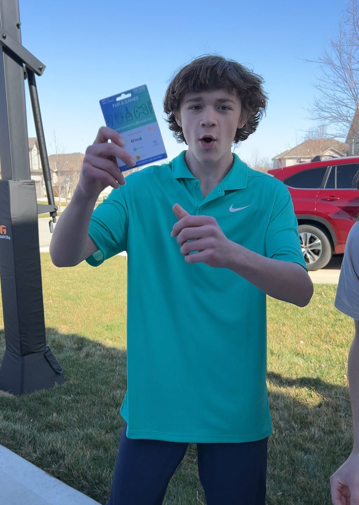 teen holding up a gift card he won in an egg hunt