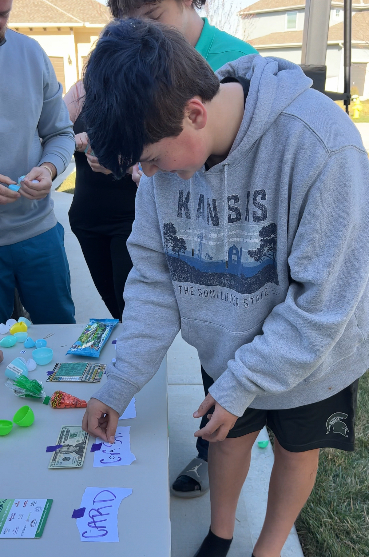 teen putting letters on a piece of paper in an egg hunt