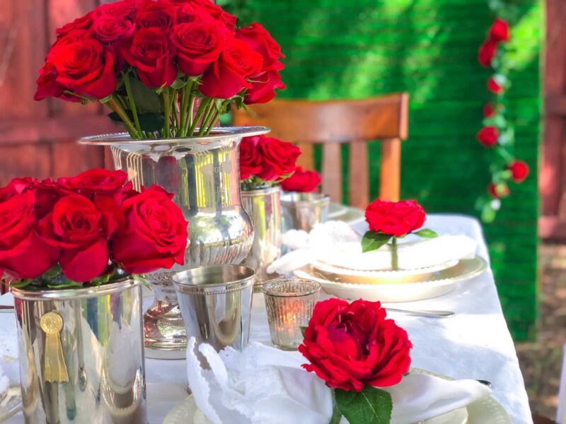 table setting with silver dishes and red roses