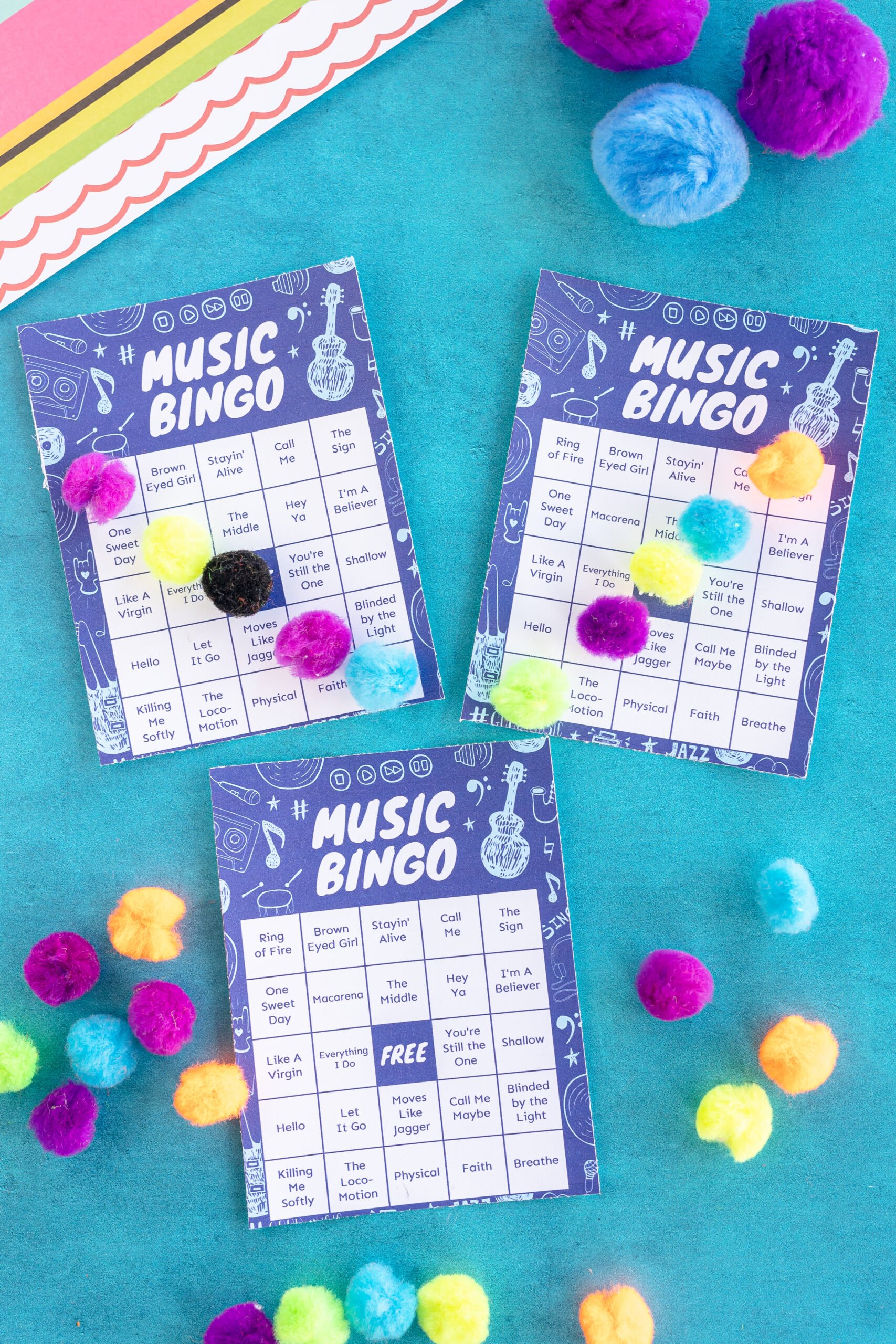 blue music bingo cards with pom poms on top