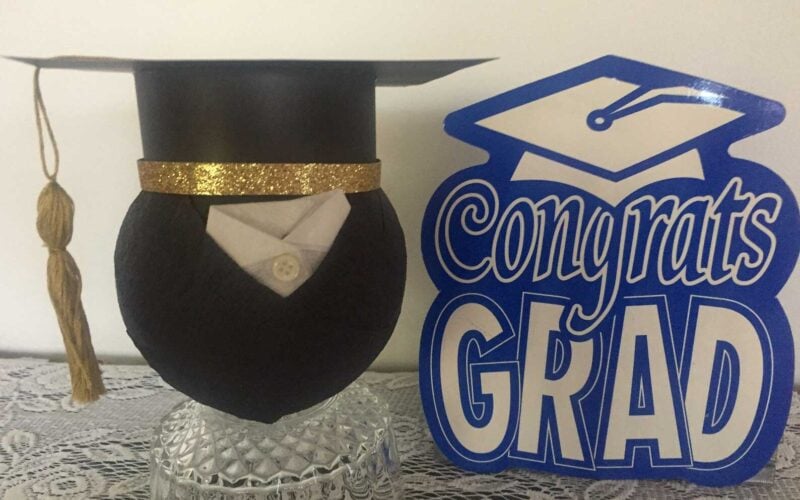 black sphere with graduation cap that is filled with a surprise