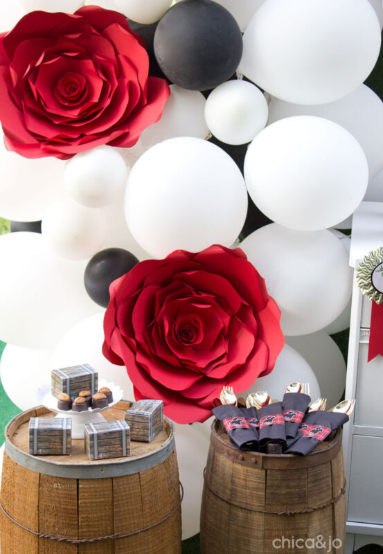 white and black balloon arch with paper roses