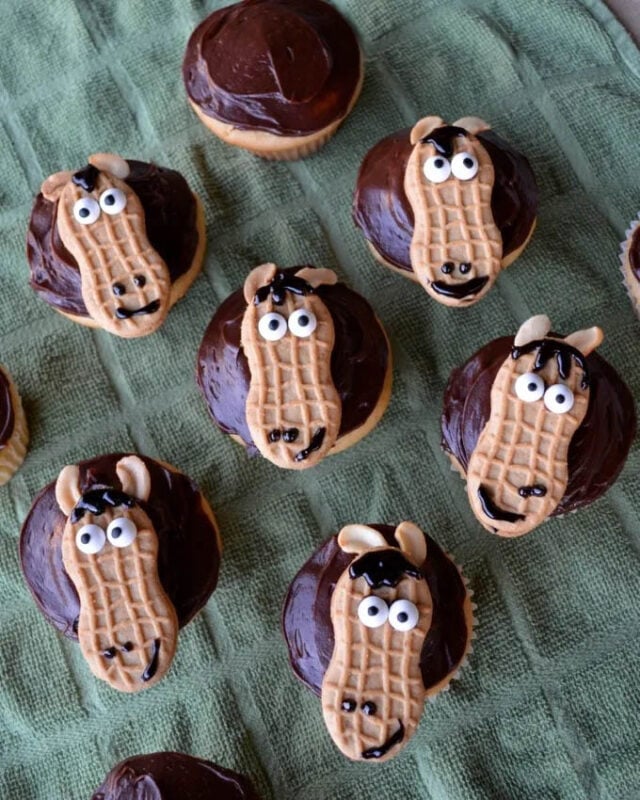 cupcake topped with decorated nutter butter that look like horse head