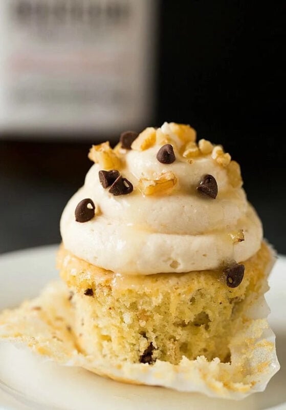 vanilla cupcake topped with white frosting, pecans, and chocolate chips