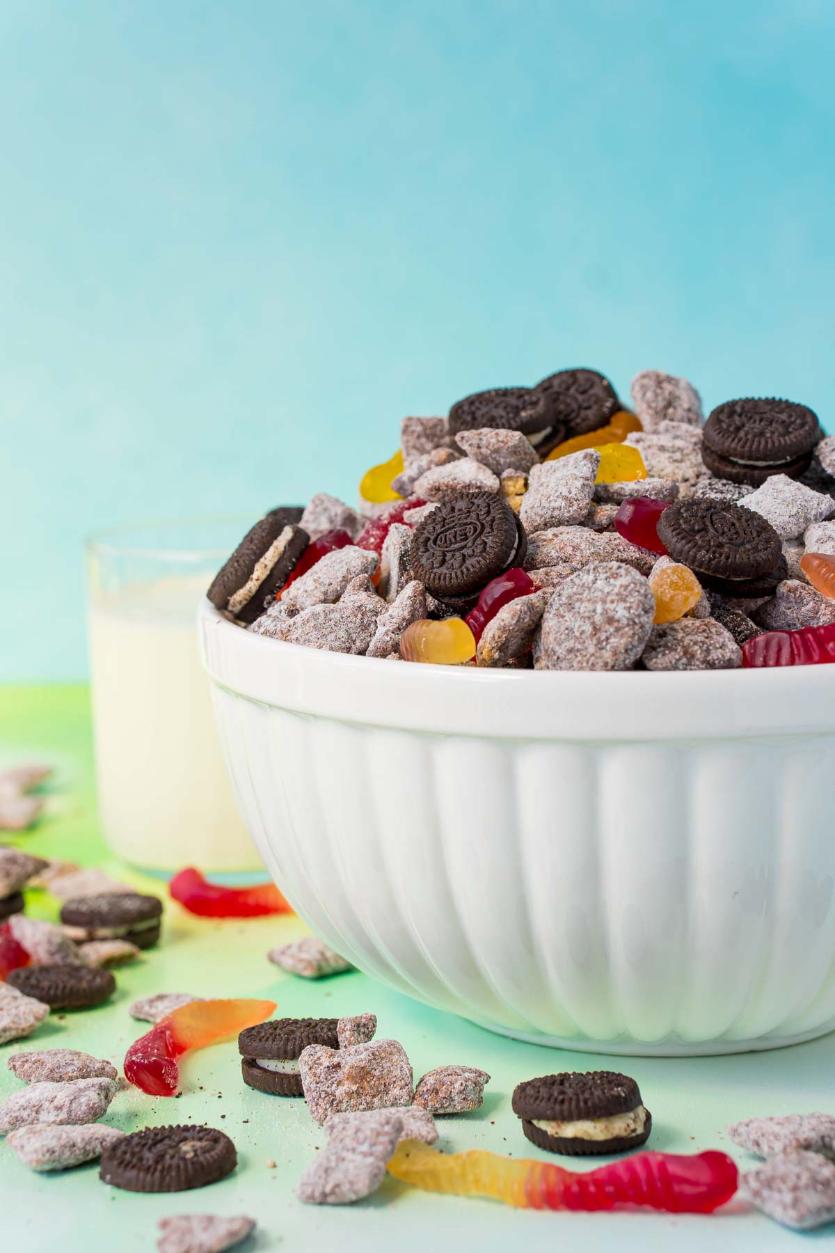 Oreo muddy buddies with gummy worms in a glass bowl