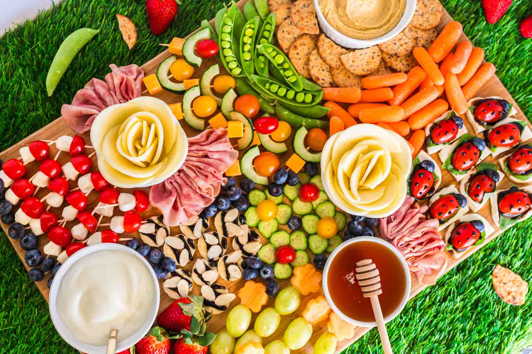 horizontal image of a picnic charcuterie board with fruit and veggies