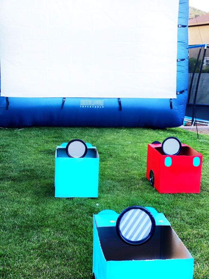 carboard car boxes facing large movie screen