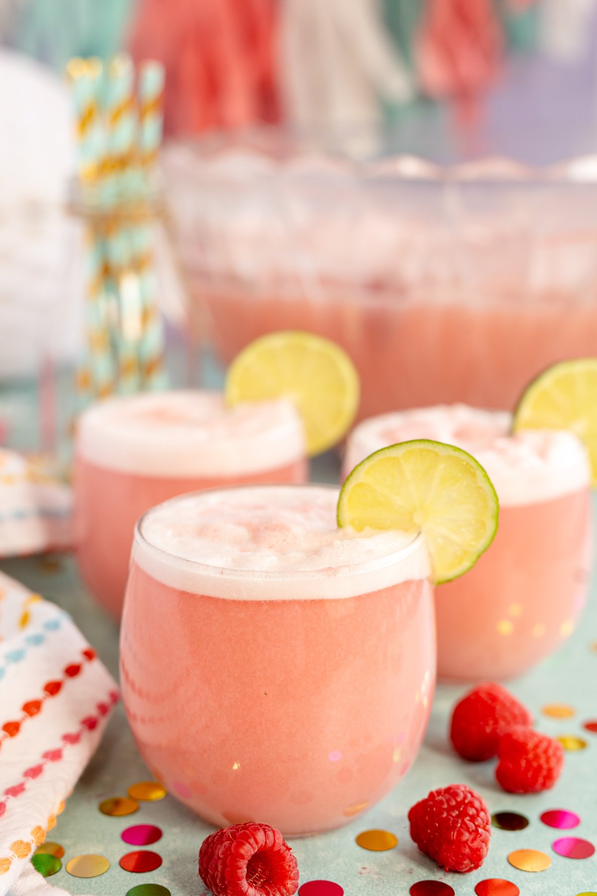 glasses of pink punch in front of a punch bowl