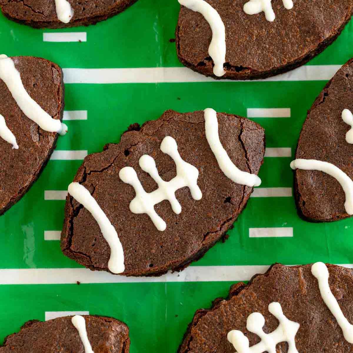 football shaped brownies with icing laces on a green tablecloth