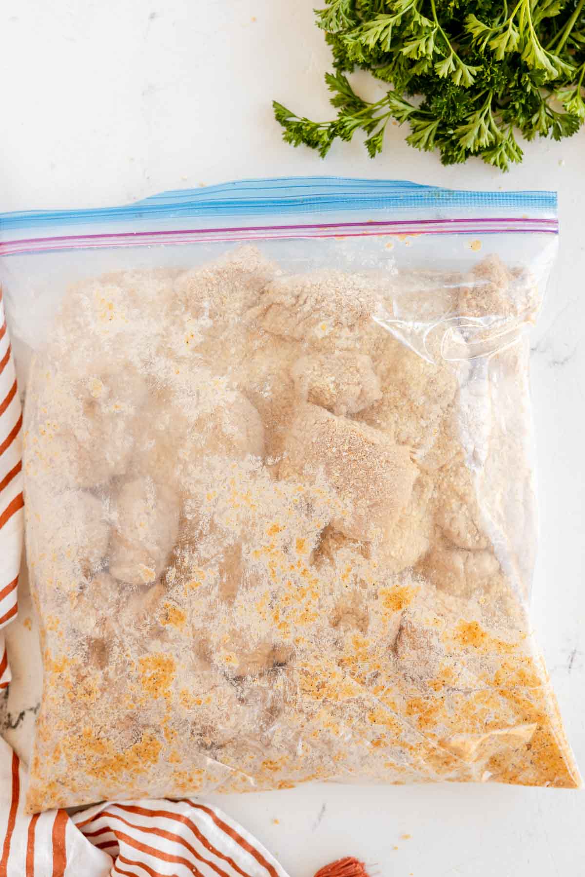 chicken pieces in a ziploc bag with breading 