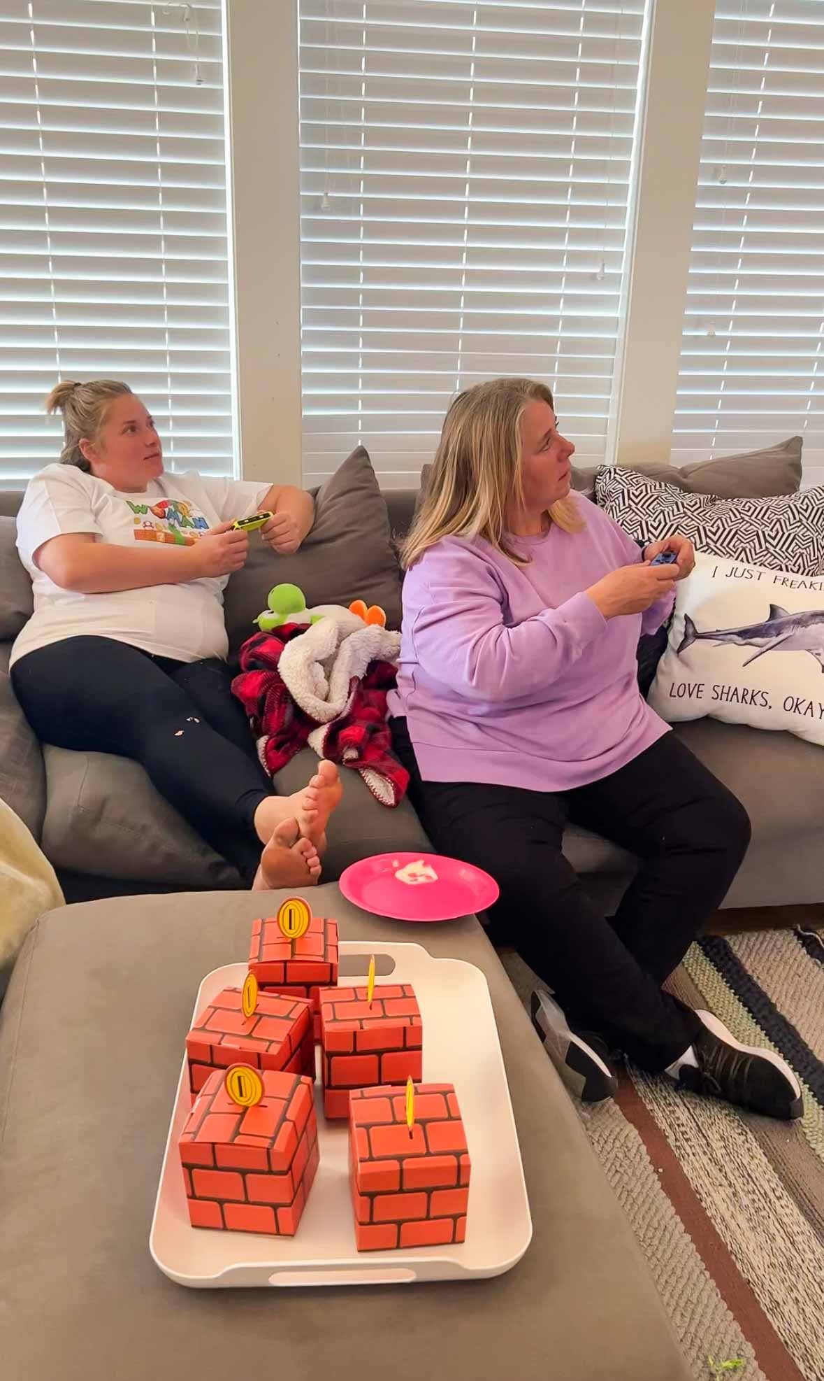 women playing Super Mario party on a couch