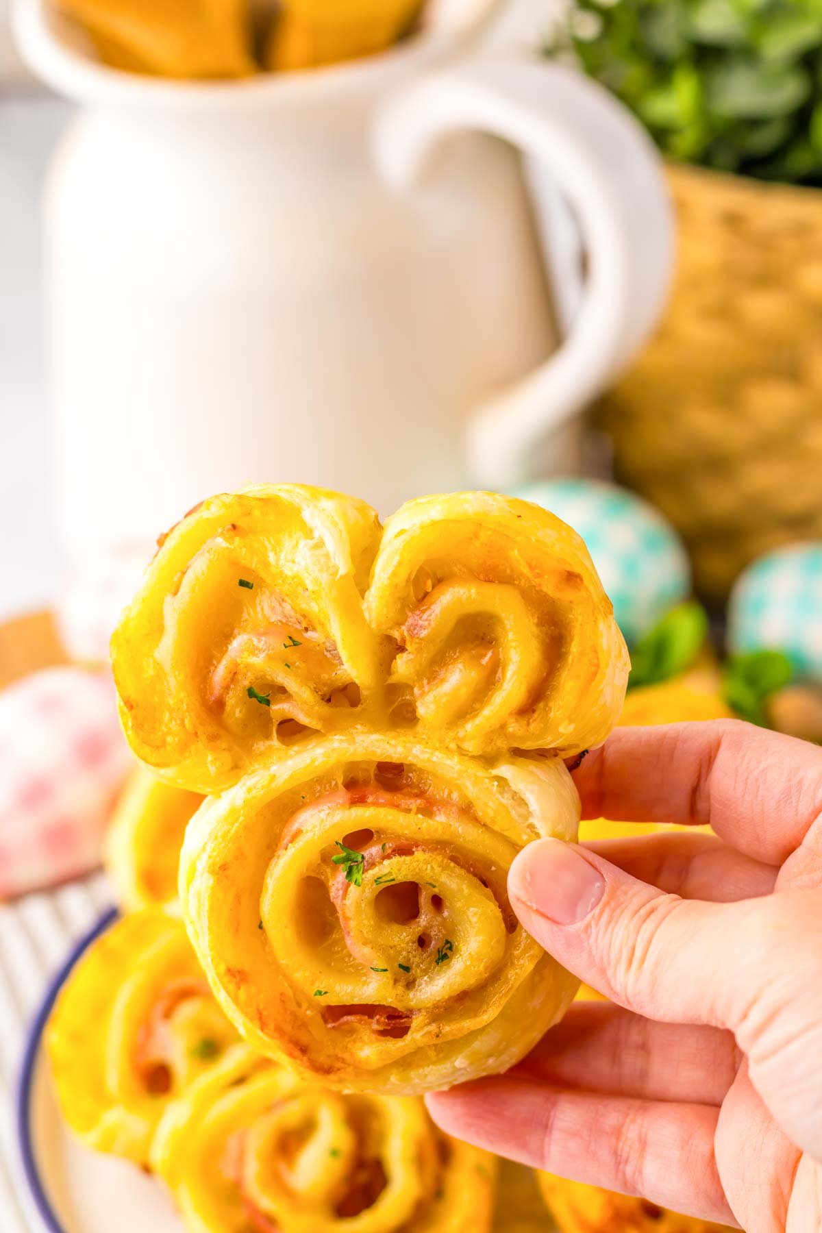 hand holding a bunny rabbit shaped ham and cheese appetizer